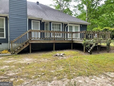 rear view of house with a lawn and a deck