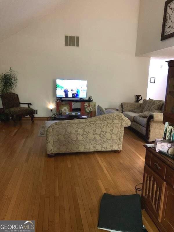 living room featuring hardwood / wood-style floors and a towering ceiling