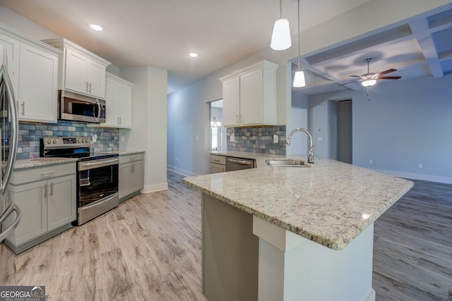 kitchen with decorative light fixtures, white cabinetry, sink, and appliances with stainless steel finishes