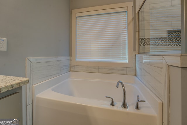 bathroom with a tub to relax in and vanity