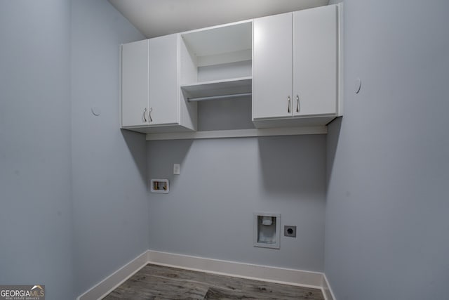 clothes washing area featuring hookup for an electric dryer, cabinets, wood-type flooring, and hookup for a washing machine