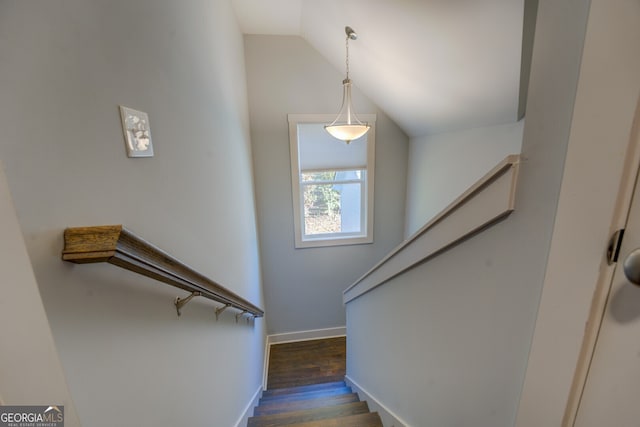 stairs featuring wood-type flooring and vaulted ceiling