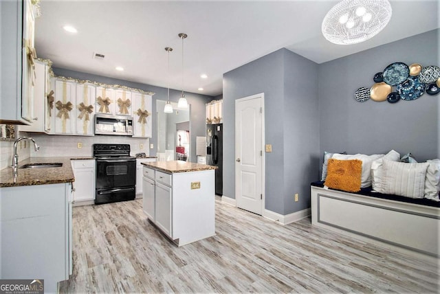 kitchen featuring sink, black appliances, pendant lighting, a center island, and white cabinetry