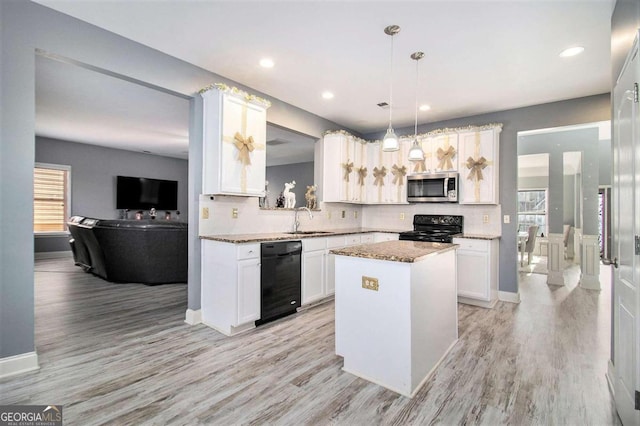 kitchen with sink, light hardwood / wood-style floors, pendant lighting, a kitchen island, and black appliances