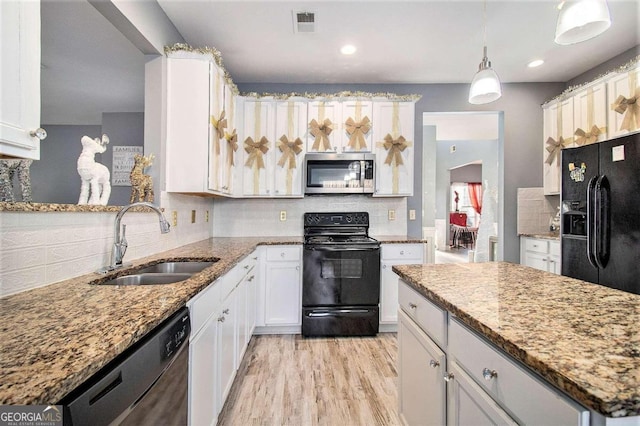 kitchen featuring white cabinetry, sink, hanging light fixtures, black appliances, and light wood-type flooring