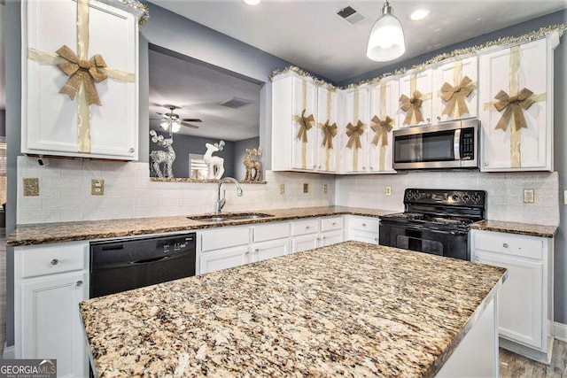 kitchen featuring white cabinetry, sink, light stone countertops, hanging light fixtures, and black appliances