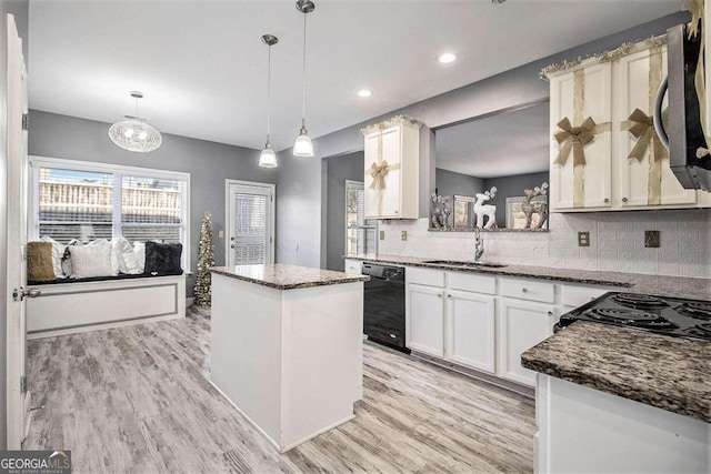 kitchen with backsplash, sink, black appliances, a center island, and hanging light fixtures