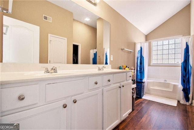 bathroom with shower / bath combo with shower curtain, wood-type flooring, vanity, and lofted ceiling