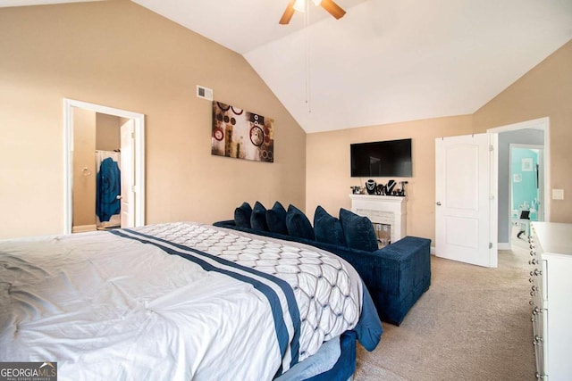 bedroom featuring light colored carpet, ceiling fan, lofted ceiling, and ensuite bathroom