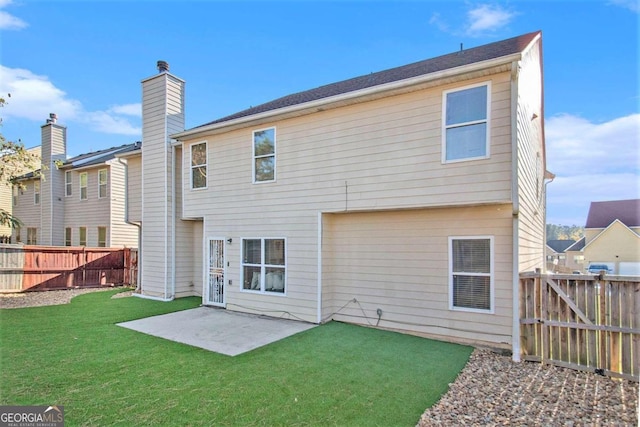 back of property with a yard and a patio