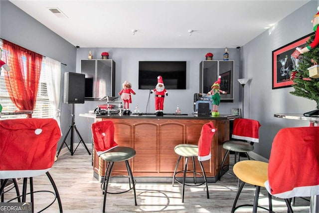 bar with light hardwood / wood-style floors