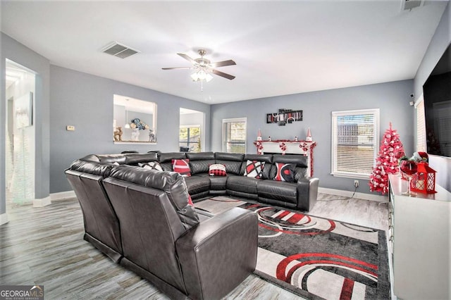 living room featuring light hardwood / wood-style floors and ceiling fan