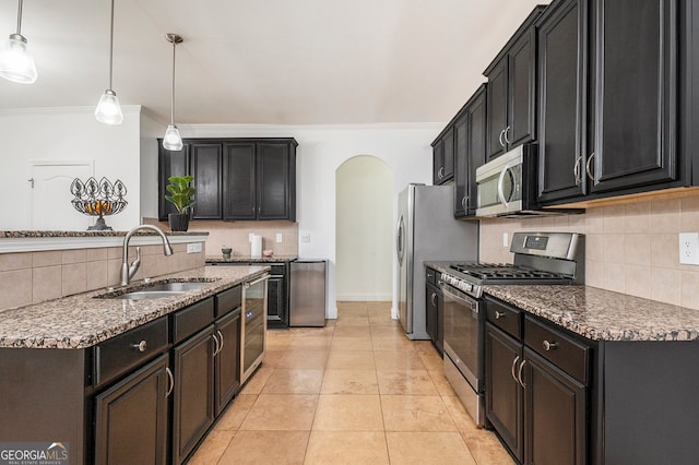 kitchen featuring tasteful backsplash, sink, hanging light fixtures, and appliances with stainless steel finishes