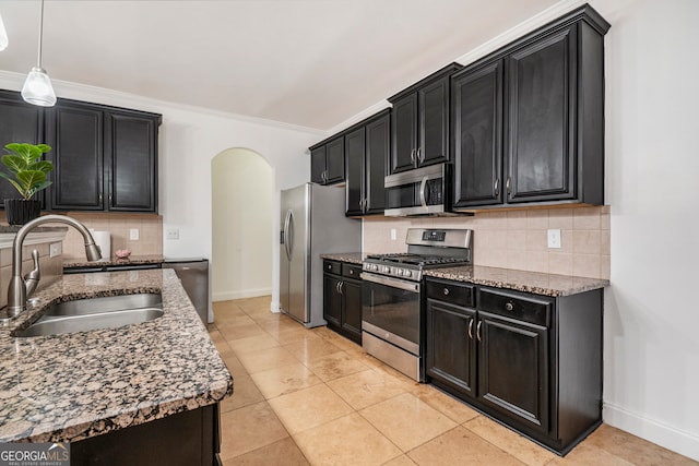 kitchen with decorative backsplash, appliances with stainless steel finishes, ornamental molding, and sink