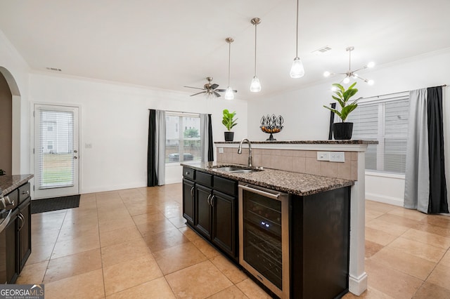 kitchen featuring ornamental molding, sink, a center island with sink, stone countertops, and wine cooler