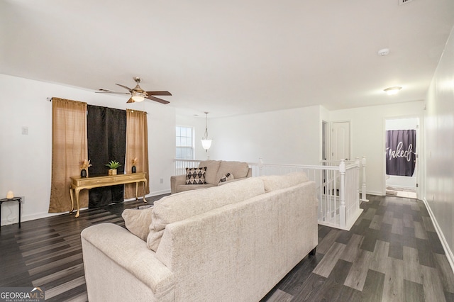 living room with ceiling fan and dark hardwood / wood-style flooring