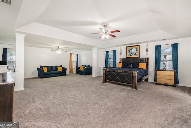 bedroom featuring a raised ceiling, multiple windows, ceiling fan, and carpet flooring