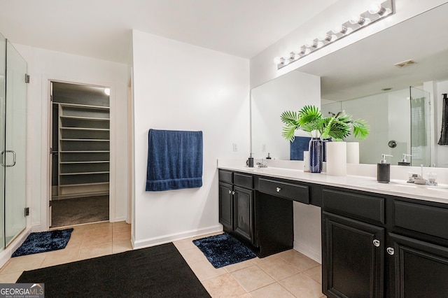 bathroom with vanity, tile patterned floors, and a shower with door