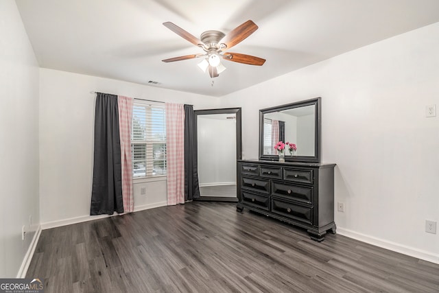 unfurnished bedroom featuring dark hardwood / wood-style floors and ceiling fan