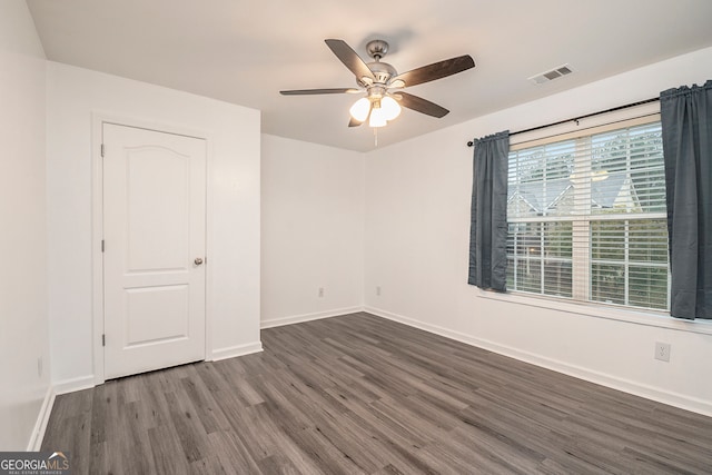 spare room with dark hardwood / wood-style floors and ceiling fan