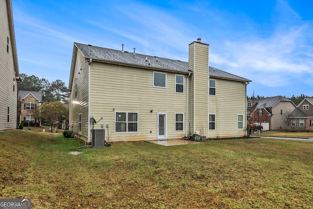 rear view of house with central air condition unit, a patio area, and a yard