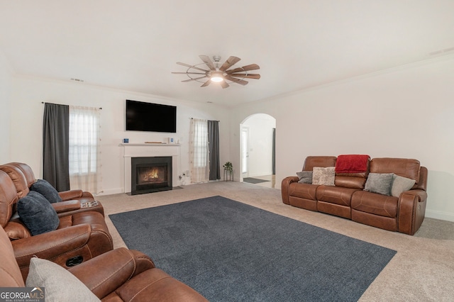 carpeted living room featuring ceiling fan and crown molding