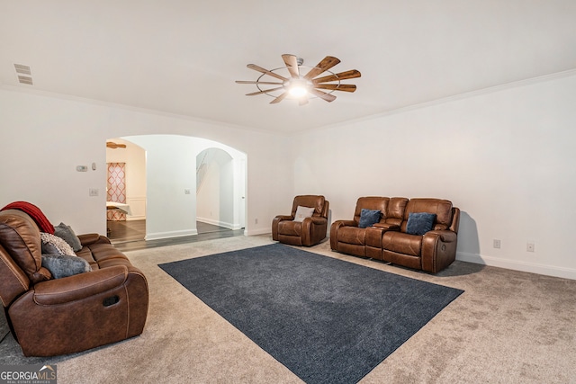 carpeted living room with ceiling fan and crown molding