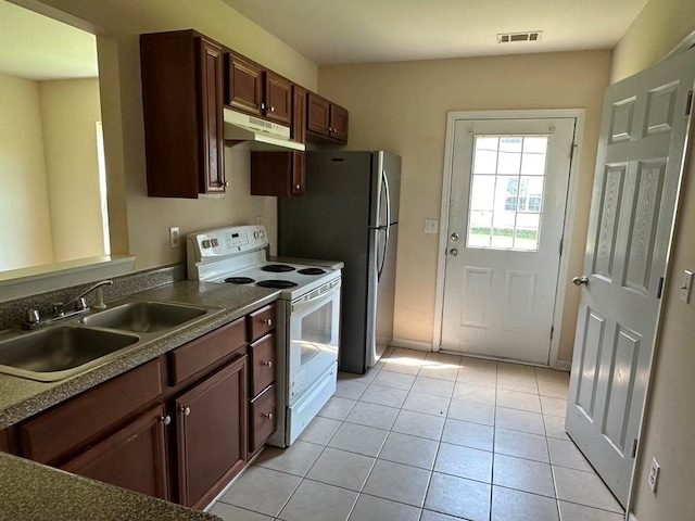 kitchen featuring light tile patterned flooring, sink, stainless steel refrigerator, and electric stove