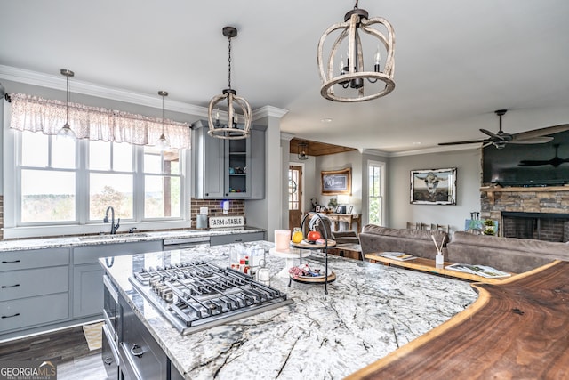 kitchen featuring gray cabinetry, sink, stainless steel appliances, dark wood-type flooring, and light stone counters