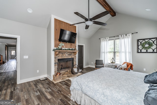 bedroom with ceiling fan, dark wood-type flooring, beam ceiling, high vaulted ceiling, and a fireplace