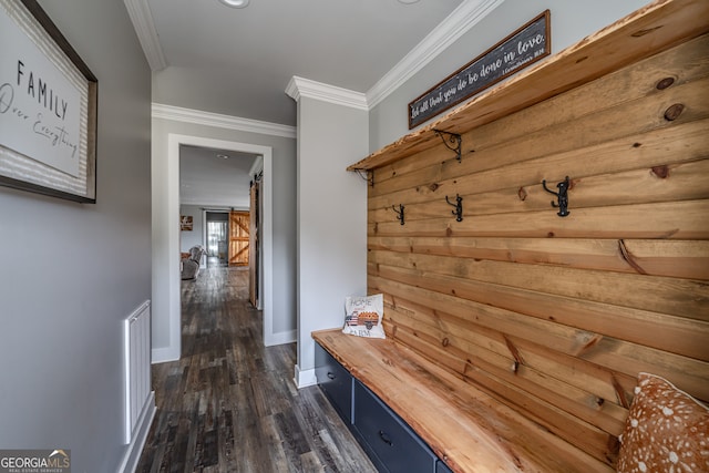 mudroom featuring a barn door, dark hardwood / wood-style flooring, and crown molding