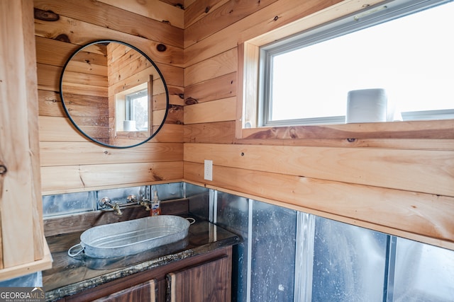 bathroom featuring vanity and wood walls