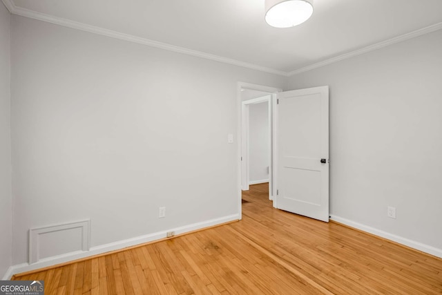 spare room featuring light hardwood / wood-style floors and crown molding