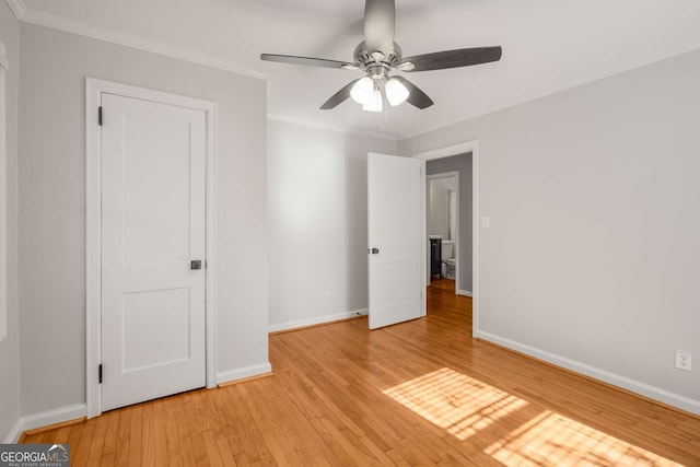 unfurnished bedroom featuring ceiling fan, crown molding, and light hardwood / wood-style floors