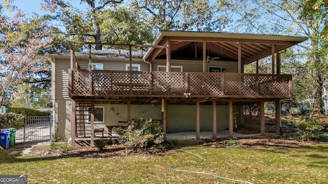 back of house with a lawn and a wooden deck