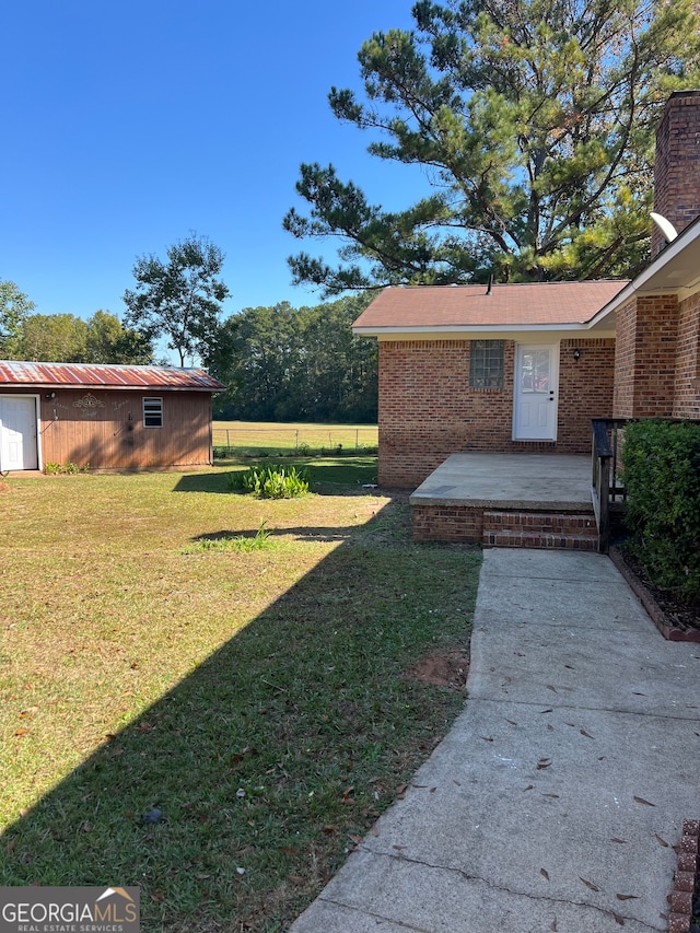 view of yard featuring an outbuilding and a patio