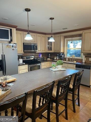 kitchen featuring light tile patterned flooring, sink, stainless steel appliances, and hanging light fixtures