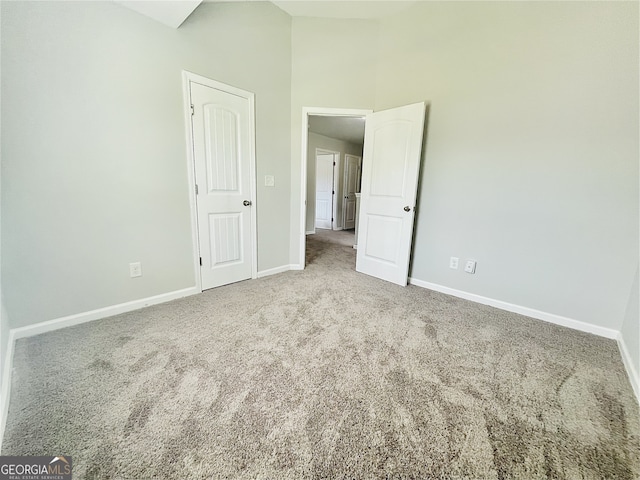 empty room featuring carpet floors and a high ceiling