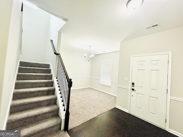 carpeted entrance foyer featuring a chandelier