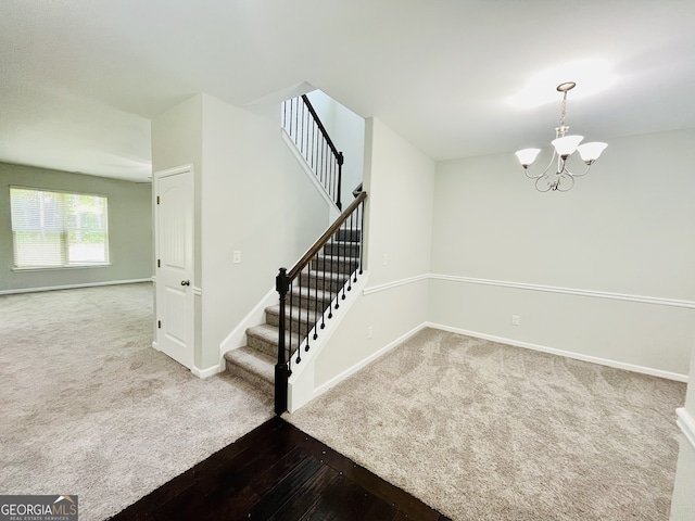 stairs with carpet floors and a chandelier