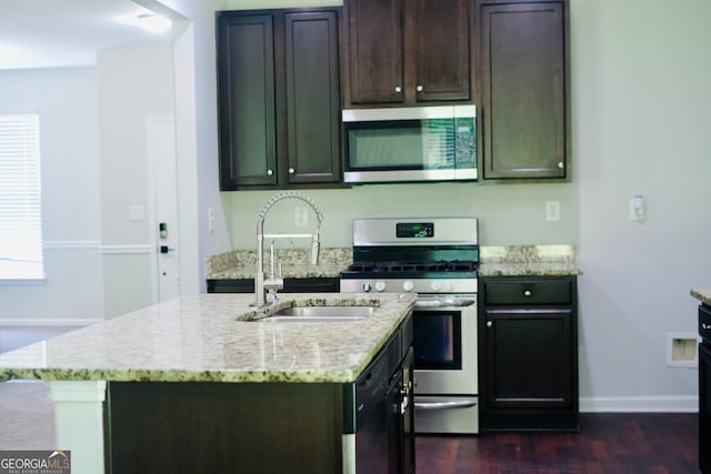 kitchen featuring sink, stainless steel appliances, and a kitchen island with sink