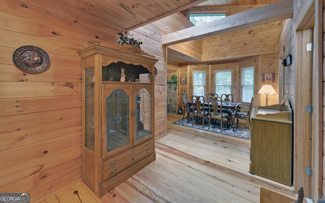 interior space featuring light hardwood / wood-style floors, vaulted ceiling, wooden ceiling, and wood walls