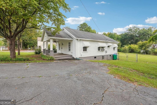 view of property exterior with a yard and a porch