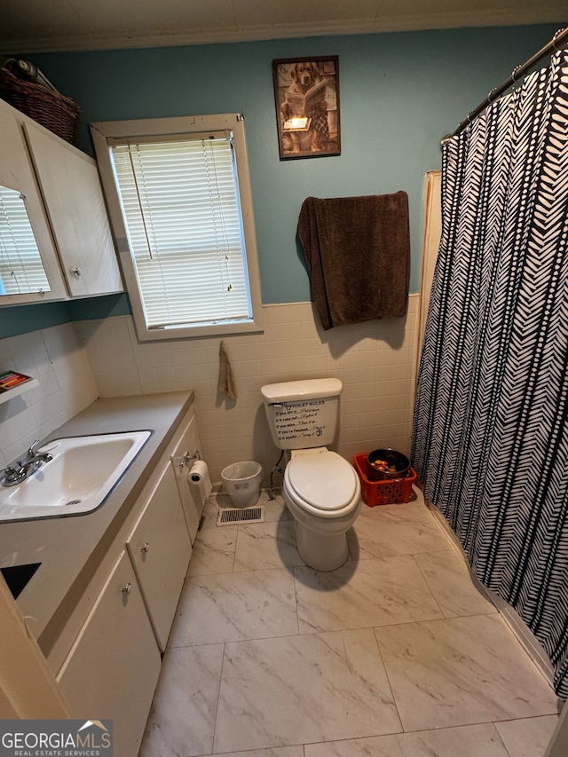 bathroom with vanity, tile walls, and toilet