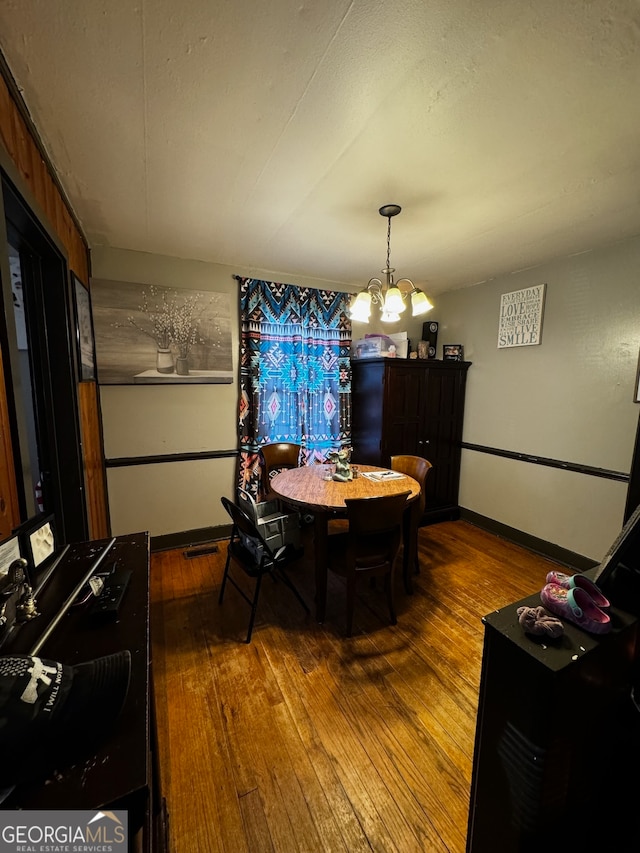 dining space with a chandelier and wood-type flooring