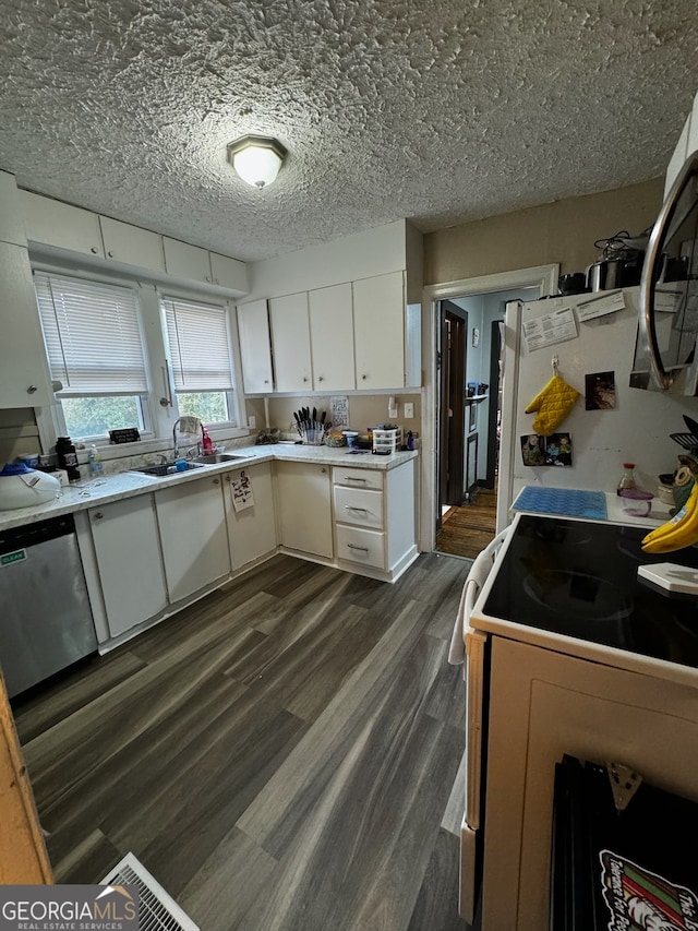 kitchen featuring white cabinets, stainless steel dishwasher, a textured ceiling, dark hardwood / wood-style flooring, and range