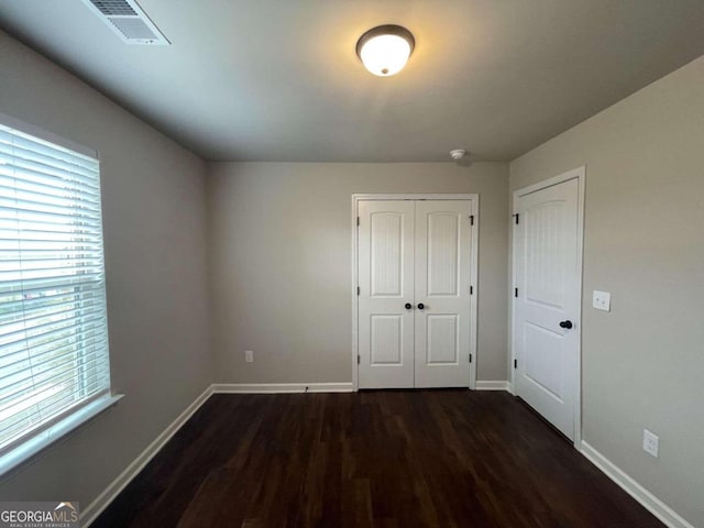 unfurnished bedroom with dark wood-type flooring