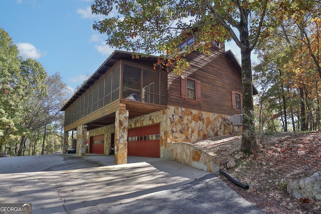 view of side of property with a sunroom and a garage