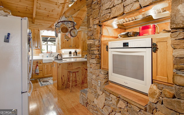 kitchen featuring white appliances, light hardwood / wood-style flooring, vaulted ceiling with beams, ceiling fan, and wood ceiling