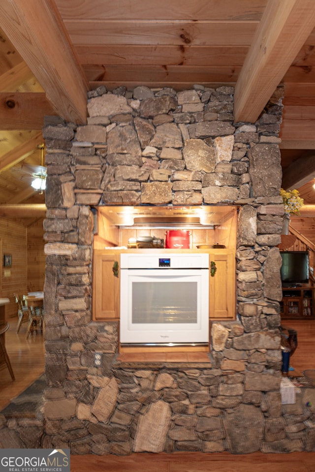 details featuring white oven, hardwood / wood-style floors, wood ceiling, and beam ceiling